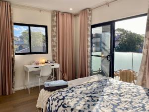 悉尼Penshurst Guest House的一间卧室配有一张床、一张书桌和一个窗户。