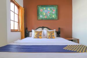 登巴萨SUPER OYO 1927 Hotel Candra Adigraha的一间卧室配有橙色墙壁的床