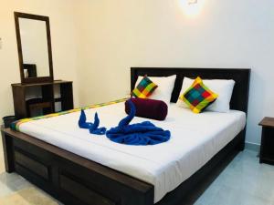 锡吉里亚Sigiri Sandilu Homestay的一间卧室配有一张带蓝色毛巾的床