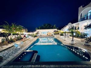 金兰Santorini Villa Cam Ranh的夜间在度假村的游泳池