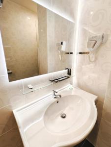 山打根Hotel Meliden的浴室设有白色水槽和镜子