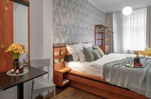 布拉格4 Elements Apartments by Adrez的一间卧室配有一张床和一张桌子,桌子上配有四柱床。