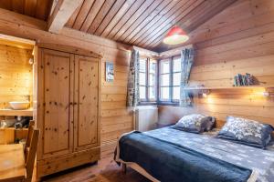 圣让德锡克斯特chalet les ecureuils的木制客房内的一间卧室,配有一张床