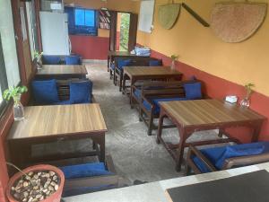 DeorāliHimalaya Serene View Guest House & Farm Stay的餐厅设有木桌和蓝色椅子
