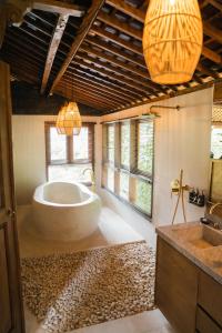 乌布Ubud Riverside Villa的一间带大浴缸和水槽的浴室