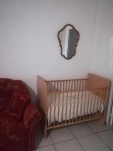 勒托尔Au pays du Ventoux的墙上有一张婴儿床和一面镜子的托儿所