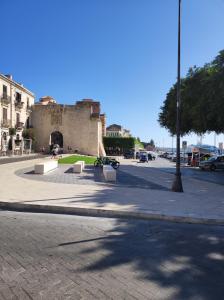 锡拉库扎Al Settimo porta marina的一条有长椅的街道和一座建筑的背景