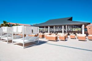 科斯塔巴伦娜Hotel Best Costa Ballena的庭院里摆放着一组躺椅和遮阳伞