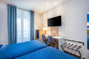 巴黎蒙帕纳斯总站酒店的酒店客房配有一张床、一张书桌和一台电视。