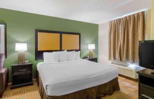 里士满里士满西布罗德街格伦赛德北美国长住酒店的配有一张床和一台平面电视的酒店客房