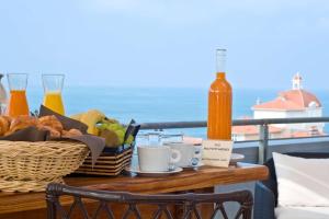 比亚里茨比亚丽兹丽笙酒店的阳台上的桌子上放着一篮子的食物和饮料