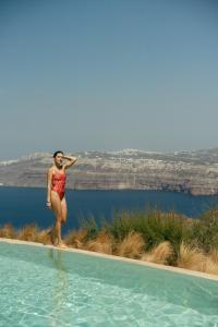 阿克罗蒂里Divino Caldera的站在游泳池旁的比基尼的女人