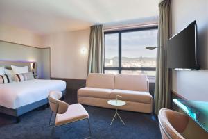 克莱蒙费朗Aiden by Best Western Clermont-Ferrand - Le Magnetic Hotel & Spa的酒店客房,配有床和沙发