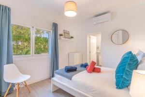 穆罗海滩Casa a metros del Mar的卧室配有床、椅子和窗户。