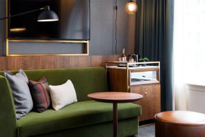 西雅图The Alexis Royal Sonesta Hotel Seattle的客厅配有绿色沙发和桌子