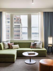 西雅图The Alexis Royal Sonesta Hotel Seattle的客厅设有绿色沙发和窗户。