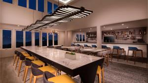 西雅茅斯Aiden by Best Western Cape Cod - West Yarmouth的大型用餐室配有长桌和椅子