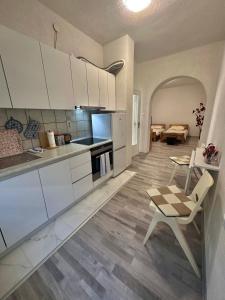 萨拉热窝Apartment Rea Ilidža 2的厨房配有白色橱柜、桌子和椅子