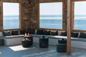 凯勒里瓦迪Radisson Blu Euphoria Resort, Mykonos的客厅配有沙发、桌子和窗户
