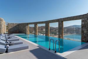凯勒里瓦迪Radisson Blu Euphoria Resort, Mykonos的蓝色的游泳池和窗户