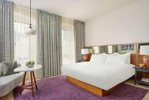 纳什维尔The Bankers Alley Hotel Nashville, Tapestry Collection by Hilton的卧室配有一张白色的大床和一张沙发。