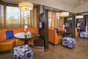 夏洛特夏洛特大学研究园万怡酒店的一间备有橙色椅子和桌子的等候室