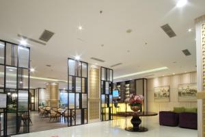 三宝垄印度尼西亚滕特雷姆酒店管理经营香蒂酒店的大楼的大堂,配有桌椅