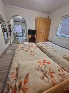 萨拉热窝Apartment Rea Ilidža 2的一间卧室配有一张带花卉图案的毯子的大床