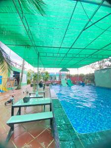Ấp Vĩnh HưngHomestay Cô Hai Garden的蓝色屋顶的大型游泳池