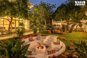 新德里StayVista's Indraj Manor - Roman-Inspired Villa with Posh Interiors, Mesmerizing Garden & Outdoor Fireplace的院子中间的火坑