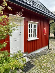 拉尔维克Tollgaarden Gjestegaard的一间红色的房子,有白色的门和窗户