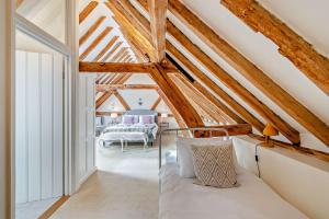 希思菲尔德Court Lodge Oast的带木天花板的阁楼卧室配有一张床。
