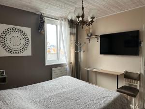 滨海贝尔克Villa les Buissonets的一间卧室配有一张床和一台平面电视
