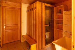 莱热Chalet R'Mize的厨房配有木制橱柜、水槽和冰箱。