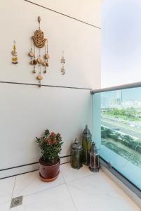 迪拜Private Room in Bright & Cozy Apt Near Downtown, Near Metro, Pool, Gym的一间有窗户的房间和盆栽植物