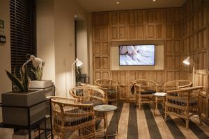 里斯本room Select Liberdade的一间设有藤椅和电视的等候室