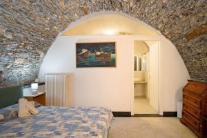 切尔沃Dipinti, borgo dei pescatori的一间卧室设有一张床和石墙