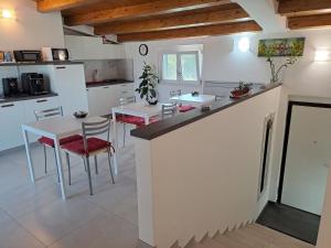 奥托纳Tana del Riccio的厨房配有白色的柜台和桌椅