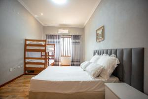 蓬塔杜欧鲁Ponta d’ ouro lia’s house的一间卧室配有带白色床单和枕头的床。