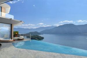 萨拉科马奇纳Villa Osee Lago di Como的水景房屋 - 带游泳池