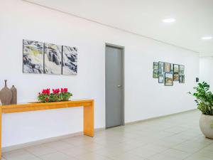 皮拉西卡巴ibis Piracicaba的墙上有桌子和鲜花的房间