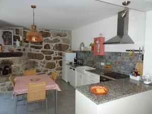 特拉什杜博鲁A CASA COM 2 PEREIRAS的厨房配有桌椅和石墙