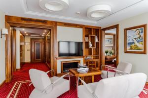索波特Haffner Hotel & SPA Sopot的客厅配有白色椅子和电视