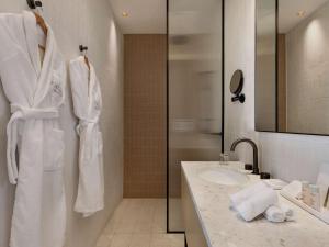 特拉维夫Elkonin Tel Aviv - MGallery Hotel Collection的白色的浴室设有水槽和淋浴。