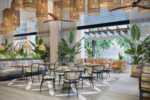 Anse a La MoucheCanopy By Hilton Seychelles的一间设有桌椅的餐厅,种植了植物