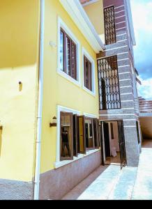 阿布贾Select Elegant 3 Rooms 3 sized king-bed @ Abuja FCT的街上的黄色房子,窗户