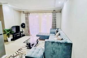 哈拉雷3 Bed House in Malbereign Harare的客厅配有蓝色的沙发和桌子