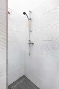 布达佩斯V26 Freedom Lodge Apartment的白色瓷砖浴室内的淋浴