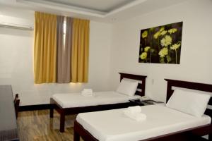 MamburaoIsla De Oro Hotel的客房设有两张床和窗户。
