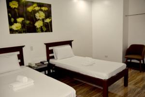 MamburaoIsla De Oro Hotel的墙上画画的房间里设有两张床